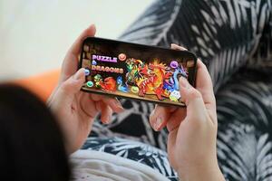 Puzzle and dragons mobile iOS game on iPhone 15 smartphone screen in female hands during mobile gameplay photo