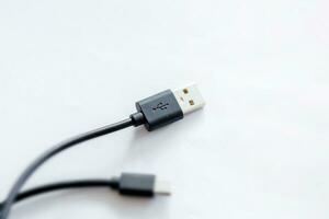 Close-up of black USB charging cable, compatible for many devices, isolated on white background. photo