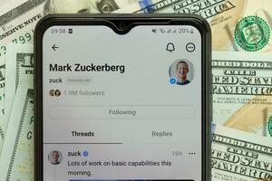 KYIV, UKRAINE - JULY 7, 2023 Threads by Meta application on display of Samsung smartphone and many dollar bills photo