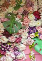 Floral background. Lot of artificial flowers in colorful composition on handmade wooden pink background photo