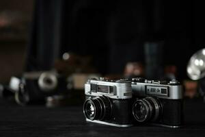 KHARKOV, UKRAINE - APRIL 27, 2021 Fed 4 and 5b Film photo camera and another old retro photo equipment on black wooden table in photographer darkroom. Photographic gear from soviet union