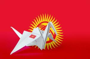 Kyrgyzstan flag depicted on paper origami crane wing. Handmade arts concept photo