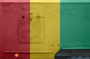 Guinea flag depicted on side part of military armored truck closeup. Army forces conceptual background photo