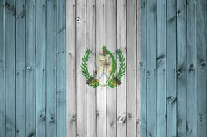 Guatemala bandera representado en brillante pintar colores en antiguo de madera pared. texturizado bandera en áspero antecedentes foto