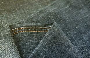 textura abstracta detallada de tela vaquera azul oscuro. imagen de fondo de la vieja tela de pantalones de mezclilla usada foto