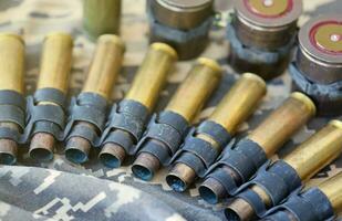 Ukrainian army fabric and machine gun belt shells lies on ukrainian pixeled military camouflage photo