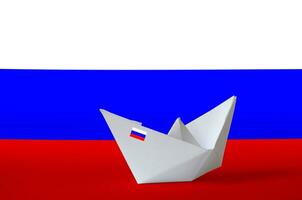 Russia flag depicted on paper origami ship closeup. Handmade arts concept photo