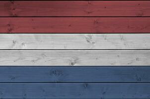 Netherlands flag depicted in bright paint colors on old wooden wall. Textured banner on rough background photo