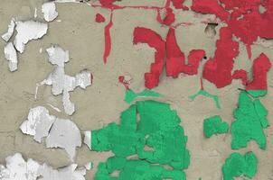 Madagascar flag depicted in paint colors on old obsolete messy concrete wall closeup. Textured banner on rough background photo