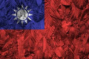 Taiwan flag depicted on many leafs of monstera palm trees. Trendy fashionable backdrop photo