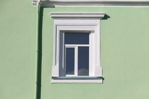 Vintage white window on mint green wall in sunlight photo