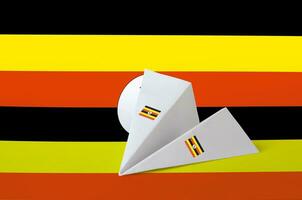 Uganda flag depicted on paper origami airplane. Handmade arts concept photo