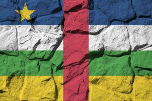 Central African Republic flag depicted in paint colors on old stone wall closeup. Textured banner on rock wall background photo