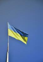 Ukrainian flag against the blue cloudless sky. The official flag of the Ukrainian state includes yellow and blue colors photo