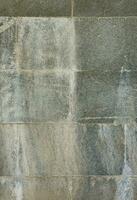 The texture of a wall of large granite tiles that are covered with white streaks when exposed to dampness photo