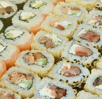 Close-up of a lot of sushi rolls with different fillings. Macro shot of cooked classic Japanese food. Background image photo