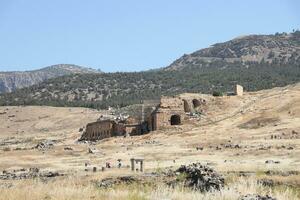 ANTALYA, TURKEY - MAY 15, 2021 Ruins of ancient city Hierapolis near Pamukkale, Turkey at sunny day. Parts of old historical buildings with big blocks photo