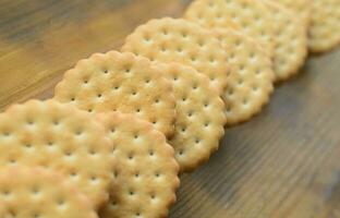 una galleta sándwich redonda con relleno de coco se encuentra en grandes cantidades sobre una superficie de madera marrón. foto de golosinas comestibles sobre un fondo de madera con espacio de copia