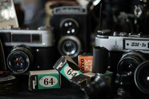 KHARKOV, UKRAINE - APRIL 27, 2021 Film photo cameras and another old retro photo equipment on black wooden table in photographer darkroom. Photographic gear from soviet union