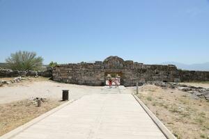 ANTALYA, TURKEY - MAY 15, 2021 Ruins of ancient city Hierapolis near Pamukkale, Turkey at sunny day. Parts of old historical buildings with big blocks photo