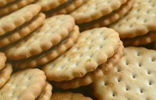 imagen detallada de galletas sándwich redondas con relleno de coco. imagen de fondo de un primer plano de varias golosinas para el té foto