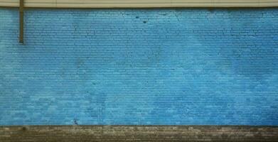 The texture of the brick wall of many rows of bricks painted in blue color photo