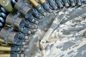 Ukrainian army fabric and machine gun belt shells lies on ukrainian pixeled military camouflage photo