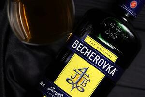 KHARKOV, UKRAINE - DECEMBER 3, 2020 Becherovka herbal liqueur bottle on dark black background. Elite alcohol photo