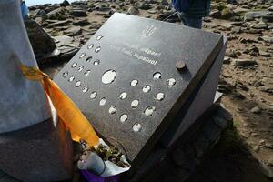 CARPATHIAN MOUNTAINS, UKRAINE - OCTOBER 8, 2022 Ukrainian monument at peak of Hoverla mountain in Carpathians photo