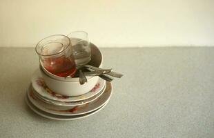 Stack of dirty dishes with food leftovers on the table after meal. Banquet ending concept. Unwashed dishes photo