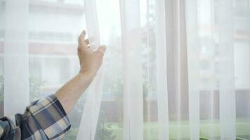 unzufrieden alt Mann suchen aus das Fenster. video