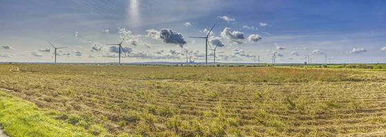 Panoramic image of a wind farm with a coal-fired power plant in the background photo