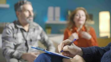 psychiater nemen aantekeningen terwijl getrouwd paar bespreken. familie problemen. video