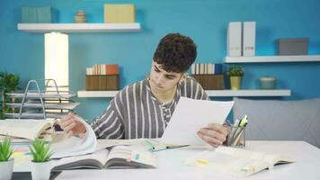 das Schüler studieren beim Zuhause sieht aus beim das Papiere und bekommt deprimiert. video