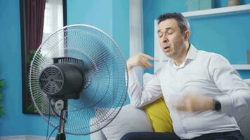 hombre molesto a frio apagado con ventilador a hogar. video