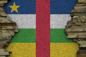 Central African Republic flag depicted in paint colors on old stone wall closeup. Textured banner on rock wall background photo