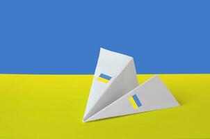 Ukraine flag depicted on paper origami airplane. Handmade arts concept photo