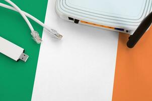 Ireland flag depicted on table with internet rj45 cable, wireless usb wifi adapter and router. Internet connection concept photo