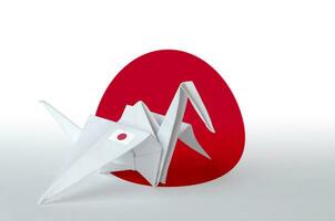 Japan flag depicted on paper origami crane wing. Handmade arts concept photo