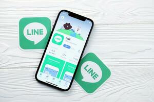 KHARKOV, UKRAINE - MARCH 5, 2021 Line messenger icon and application from App store on iPhone 12 pro display screen on white table photo