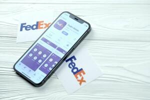 KHARKOV, UKRAINE - MARCH 5, 2021 Fedex icon and application from App store on iPhone 12 pro display screen on white table photo