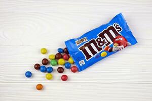 KHARKIV, UKRAINE - JANUARY 2, 2021 M and Ms colorful button shaped chocolate candies. Multi colored chocolates each of which has the letter m printed in lower case in white photo