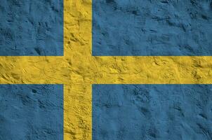 Sweden flag depicted in bright paint colors on old relief plastering wall. Textured banner on rough background photo