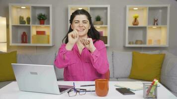 Home office worker woman dances looking at camera. video