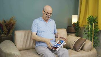 The man looking at the family album is depressed. video