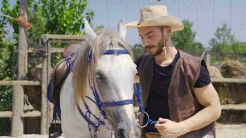 il uomo chi gli amori il criniera di il suo bianca cavallo. video