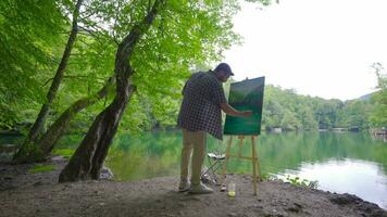 Happy painter painting outdoors. video