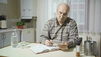 Old man looking at bills calculating at home. video