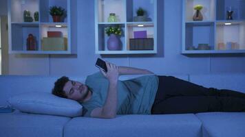 Man falling asleep at night with phone in hand. Phone addiction. video