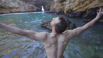 musclé homme sur falaises s'écraser dans mer vagues. video